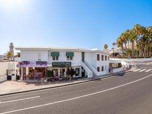 a white building on the side of a street at Rooms & Suites The Lighthouse - Puerto del Carmen, Lanzarote - Near the Beach in Tías