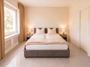 a large bedroom with a large bed with two lamps at Pension Elisa in Rheinfelden
