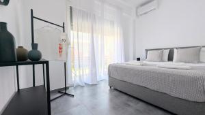 a white bedroom with a bed and a window at 9 keys in Skala Rachoniou +52 photos