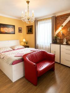 a bedroom with a bed and a red chair at Apartment Sunny Valley in Lhota u Lysic +60 photos