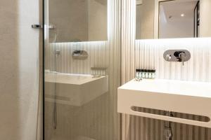 a bathroom with a sink and a glass shower at Mango Luxury Resorts in Sarandë