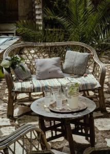 a wicker bench with a table with drinks on it at La Maison Tataouine in Moux