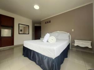 a bedroom with a bed with white sheets and pillows at Hotel Suite Santa Rosa in Santa Rosa de Cabal
