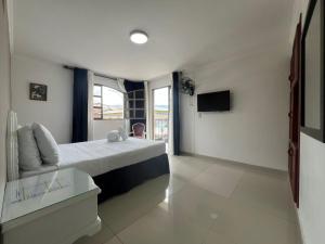 a hotel room with a bed and a tv at Hotel Suite Santa Rosa in Santa Rosa de Cabal