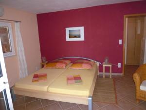 a bedroom with a bed and a red wall at Apartments Helena in Orebić