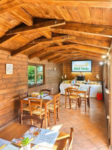 a restaurant with wooden walls and tables and chairs at B&B MULA Germaneto in Santa Maria