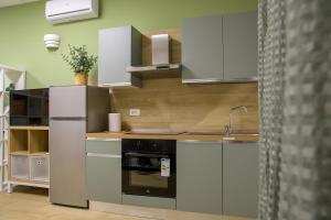 a kitchen with white cabinets and a black oven at Open Space Romagna 12 in San Benedetto del Tronto