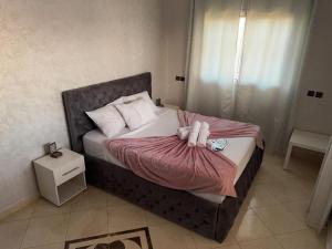 a bed with two dolls laying on top of it at villa agadir in Glalcha