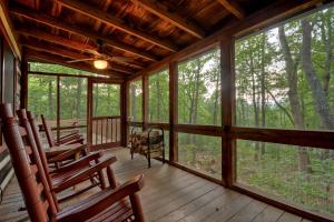 a screened in porch with rocking chairs and windows at Mountain Retreat in Morganton