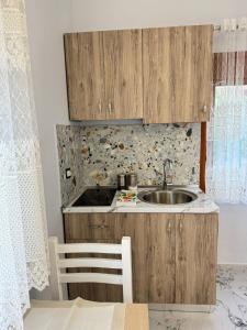 a kitchen with a sink and a wooden cabinet at Mesaiz in Vlorë +78 photos