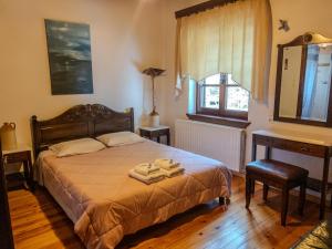 a bedroom with a bed with two towels on it at Hotel Adam in Makrinitsa