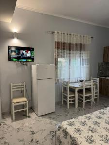 a kitchen with a refrigerator and a table and chairs at Mesaiz in Vlorë