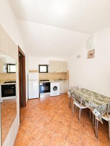 a kitchen with a table and a table and chairs at B&B MULA Germaneto in Santa Maria