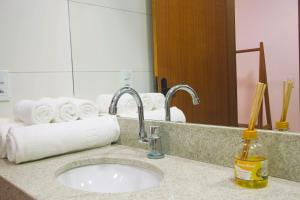 a bathroom counter with a sink and a mirror at Pousada Ilha Branca Centro in Búzios