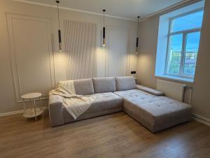 a large couch in a room with a large window at Luxe Lumine Apartment #2 in Kohtla-Järve