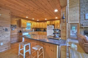 a kitchen with a large island in a log cabin at My Mountain Paradise in Morganton +24 photos
