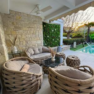 a patio with wicker chairs and a couch and a table at villa MEDITERAN in Pefkochori