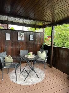 a patio with a table and chairs on a deck at Marla zum Strand in Garrel