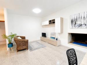 a living room with a fireplace and chairs at Center Room Tortolì wifi, AC, free parking, city center at 100 m in Tortolì