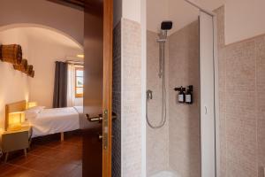 a bathroom with a walk in shower next to a bedroom at Omero in Tindari