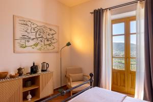 a bedroom with a bed and a window and a chair at Omero in Tindari
