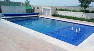 a swimming pool with blue water in a yard at Casa completa y equipada in Saucillo de la Joya