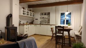 a kitchen with white cabinets and a table and a stove at Chalupa u Libuše in Lultsch