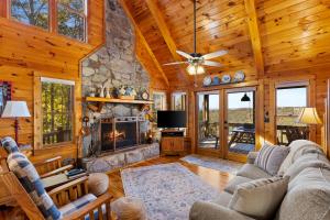 a living room with a fireplace and a stone wall at Peaks & Pines in Morganton