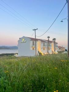 a building on the side of a field of grass at Latsis Suites in Plytra