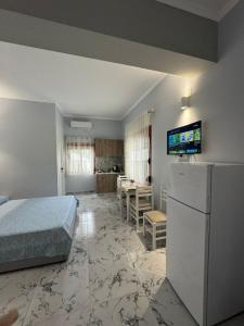 a bedroom with a bed and a kitchen with a table at Mesaiz in Vlorë