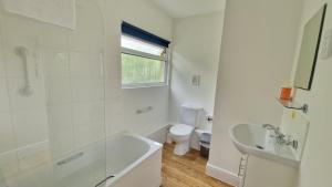 a bathroom with a tub and a sink and a toilet at 3 The Burrows in Braunton +10 photos