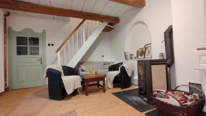a living room with a couch and chairs and a staircase at Chalupa u Libuše in Lultsch