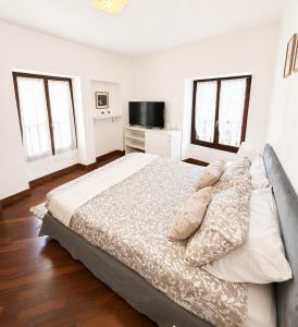 a white bedroom with a large bed with pillows at Moniga Castle Apartment in Moniga