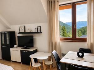 a room with a table and a table and a window at Kamzík Apartment 64 Donovaly - hneď pri lanovke a atrakciách Donovalkovo, Fun arena - Apartment near the cable car and attractions in Donovaly