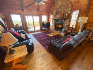 a living room with a leather couch and a fireplace at RendezView in Morganton