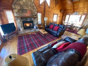 a living room with a leather couch and a fireplace at RendezView in Morganton