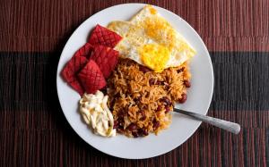 a plate of food with eggs and rice and fruit at Villalobos Hotel Managua in Managua