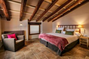 a bedroom with a large bed and a chair at Cal Compte in Torroja
