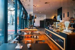 ein Restaurant mit Tischen und Stühlen in einer Cafeteria in der Unterkunft Vienna House Easy by Wyndham Berlin Prenzlauer Berg in Berlin
