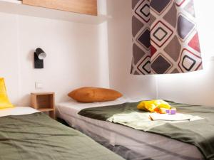 a bedroom with two beds and a painting on the wall at MOBIL-HOME "B27" tout confort avec piscine & lave-linge gratuits in Mimizan +19 photos