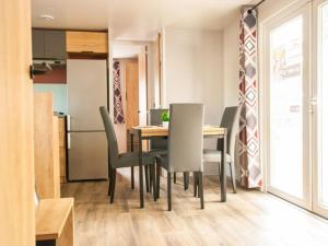 a dining room with a table and chairs at MOBIL-HOME "B27" tout confort avec piscine & lave-linge gratuits in Mimizan