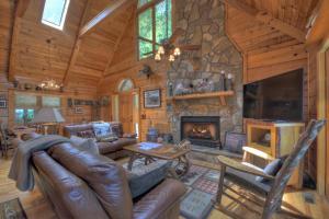 a living room with a stone fireplace in a log cabin at Storybook in Morganton