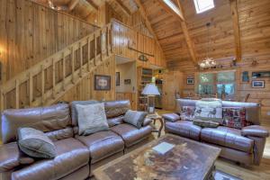 a living room with leather furniture and a wooden wall at Storybook in Morganton