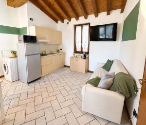 a kitchen with a couch and a refrigerator at Moniga Castle Apartment in Moniga +11 photos