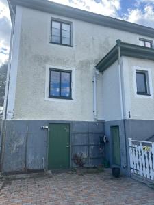 a house with two green doors and a fence at Lägenhet Övergran in Bålsta