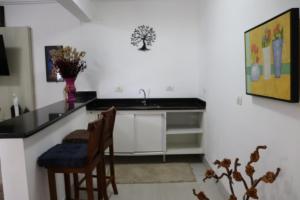 a kitchen with a sink and a table and chairs at Hotel dos Príncipes - Guarujá in Guarujá