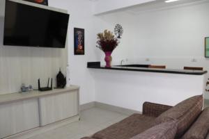 a living room with a couch and a flat screen tv at Hotel dos Príncipes - Guarujá in Guarujá