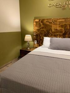 a bedroom with a large bed with a wooden headboard at Casa Hidalgo in Ciudad Hidalgo