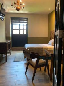 a bedroom with a bed and a table and a door at Casa Hidalgo in Ciudad Hidalgo