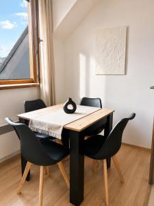 a dining room table and chairs in a room with a window at Kamzík Apartment 64 Donovaly - hneď pri lanovke a atrakciách Donovalkovo, Fun arena - Apartment near the cable car and attractions in Donovaly